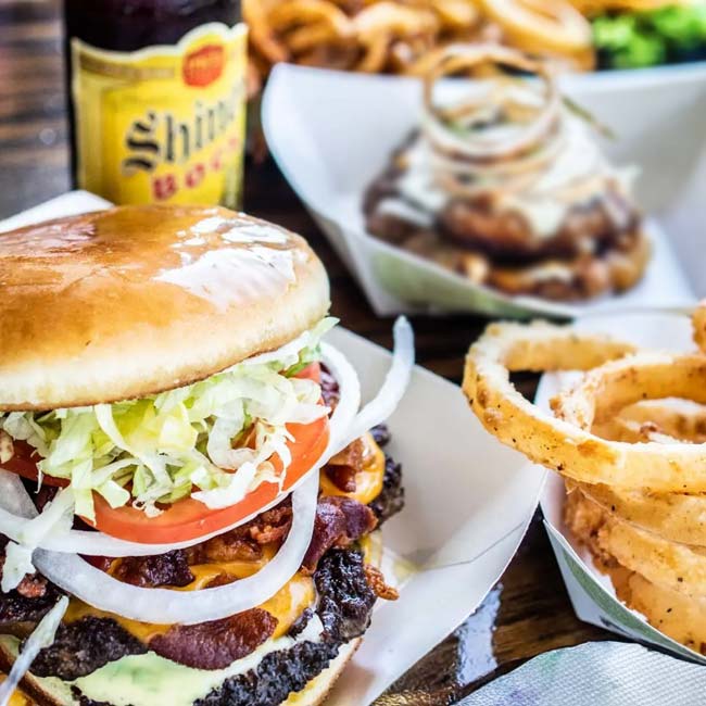 Bill's Burgers, Wings and Things restaurant and bar in Burnet, TX serves a double cheeseburger, side of onion rings and a bottled beer